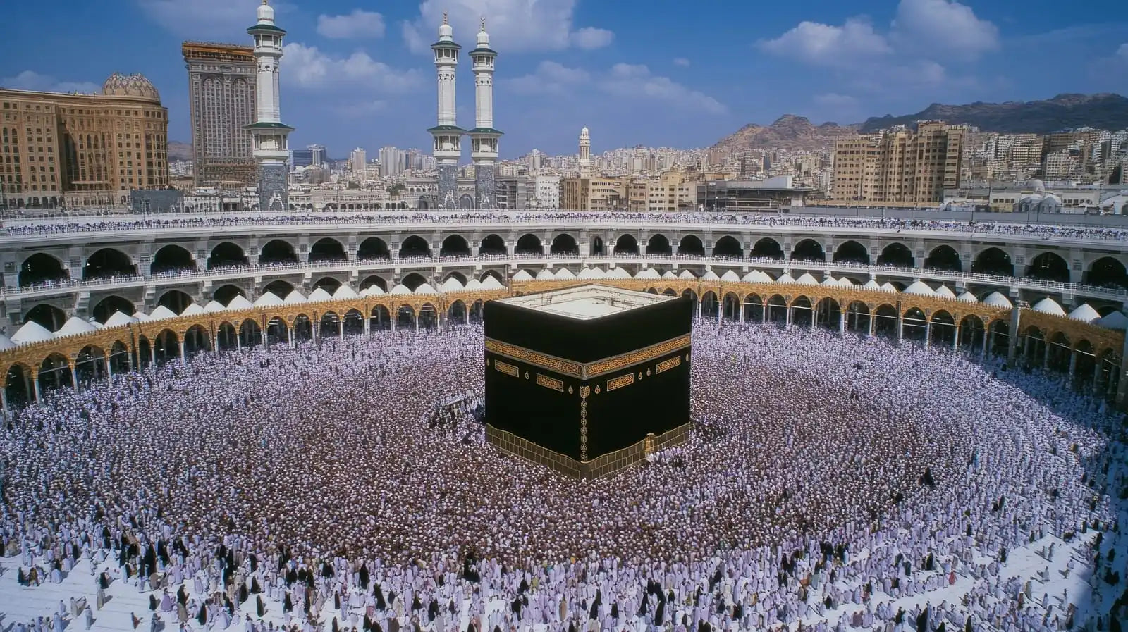 Kaaba, a black cubic structure draped in black cloth with gold embroidery, located at the center of the Grand Mosque in Mecca.